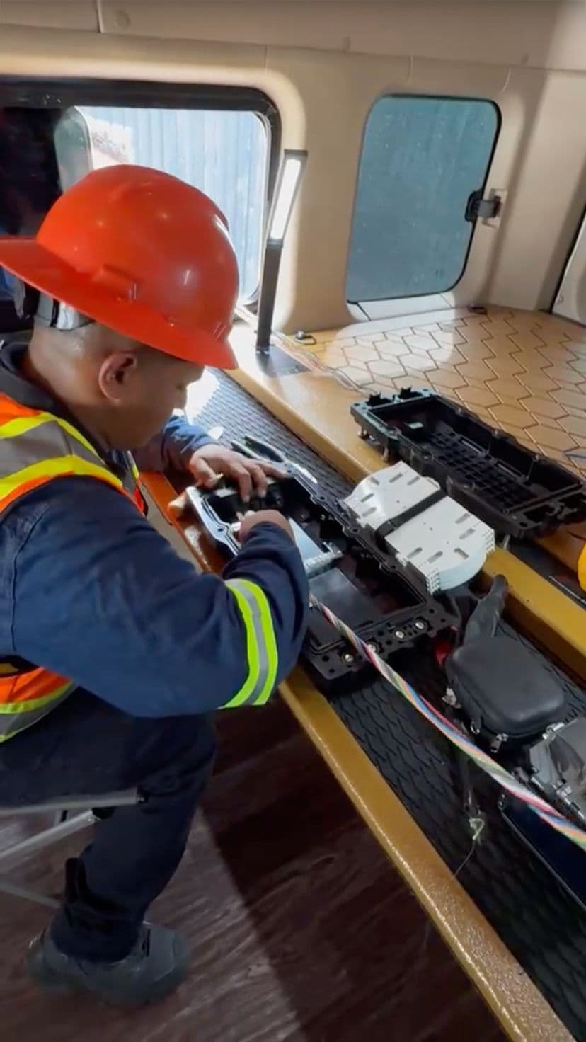Técnico preparando un empalme de fibra óptica dentro de una unidad de trabajo