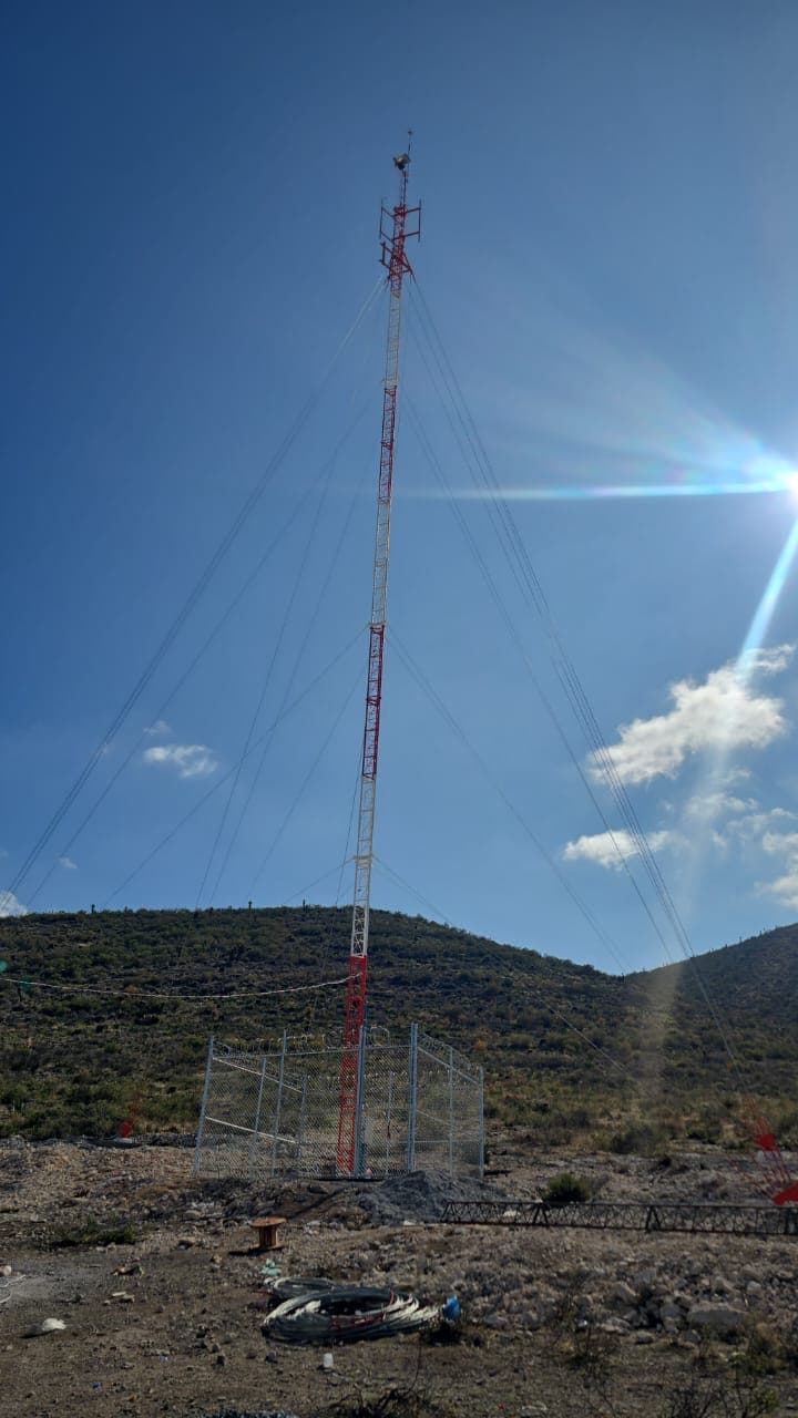 Torre arriostrada de telecomunicaciones en terreno montañoso